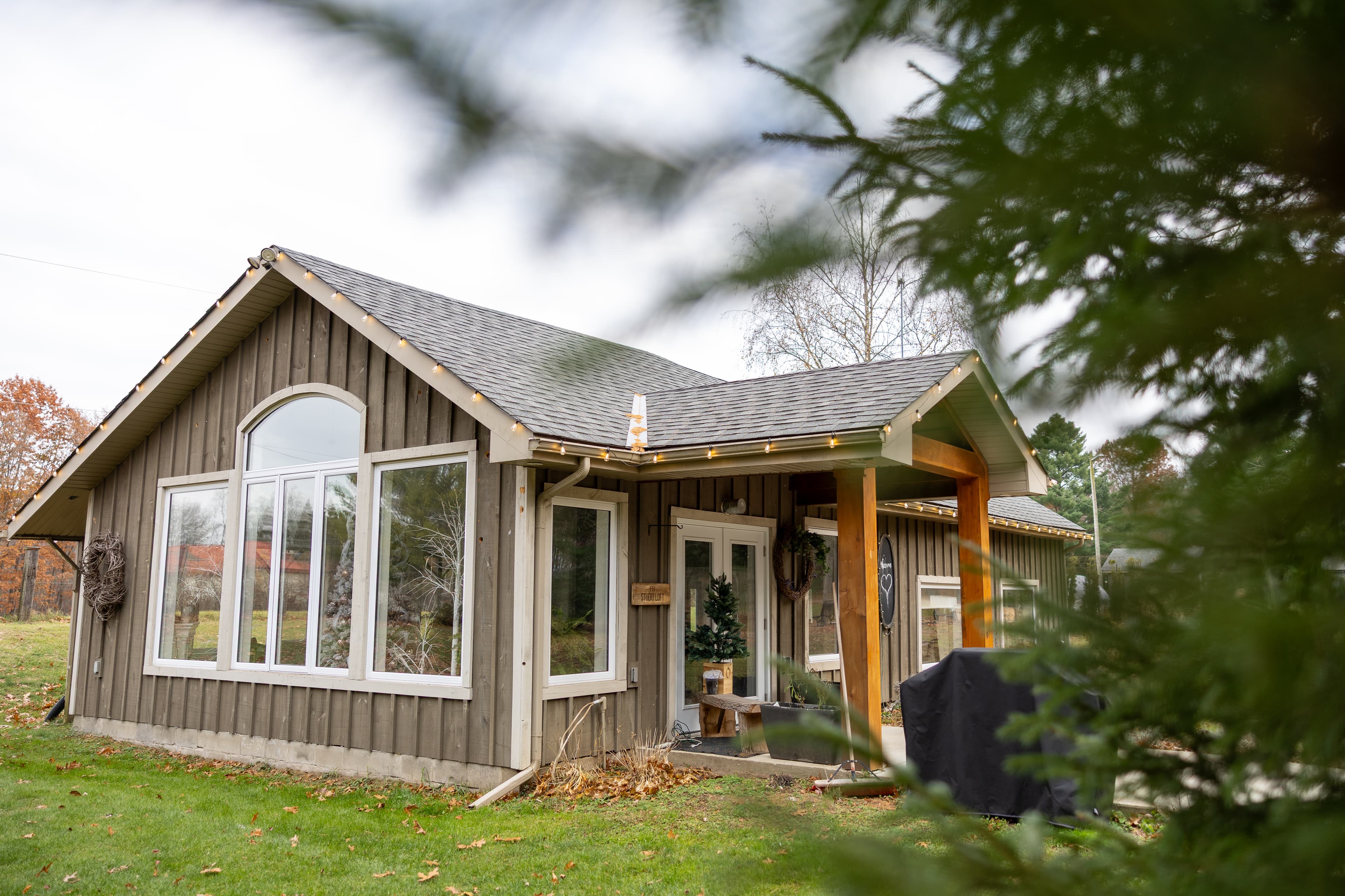 Cozy woodland cottage with big picture windows and covered porch.